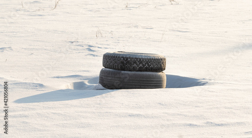 old car tires lie in the snow