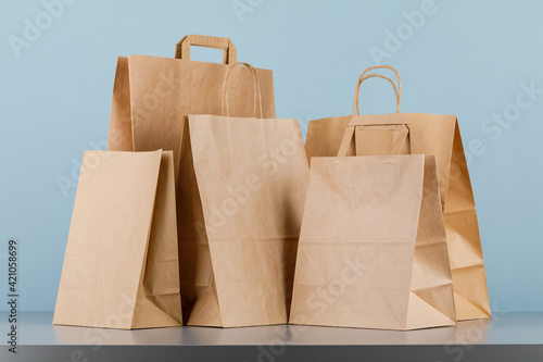 Brown paper bag with handles, empty shopping bag with area for your logo or design, food delivery concept.