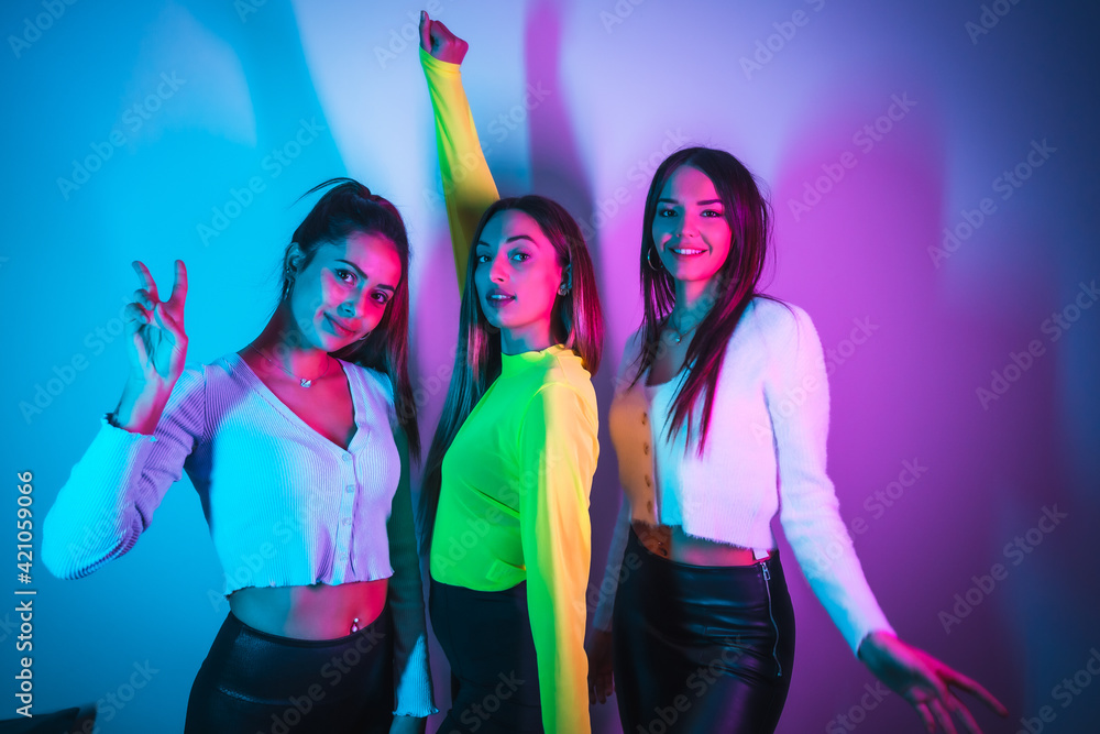 Girlfriends party lifestyle in a nightclub with blue and pink neon lights Girlfriends party lifestyle in a nightclub with blue and pink neon lights