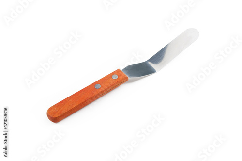 Close up palette knife with orange brown wooden handle isolated on white background. Kitchen confectionary tool utensil for cake decoration.