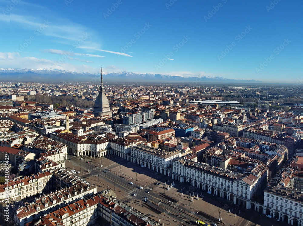 Aerial view of Turin city center, in Italy, in a sunny day, with Mole Antonelliana and Alps in the background.