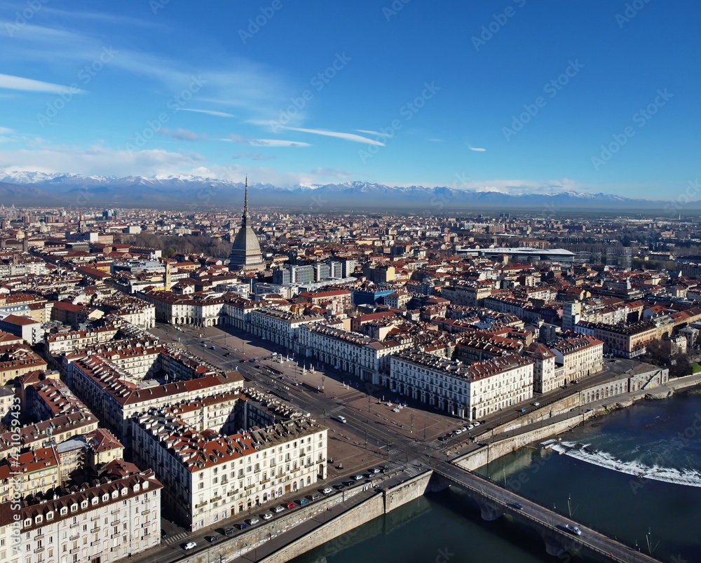 Aerial view of Turin city center, in Italy, in a sunny day, with Mole Antonelliana and Alps in the background.