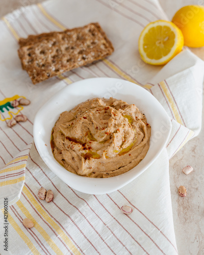 Hummus of beans and sun-dried tomatoes in a white bowl. Vegan recipe