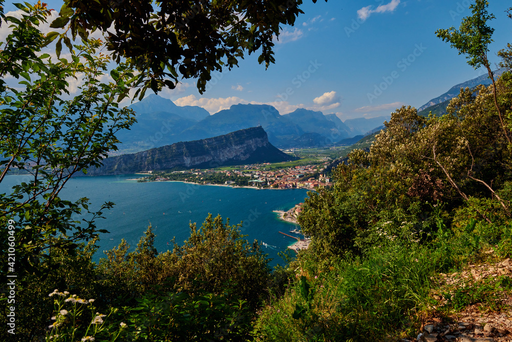 Fototapeta premium Panoramic view on Lake Garda from the Busatte-Tempesta trail near Nago-Torbole with the iron staircase, Torbole town surrounded by mountains in the summer time,Italy