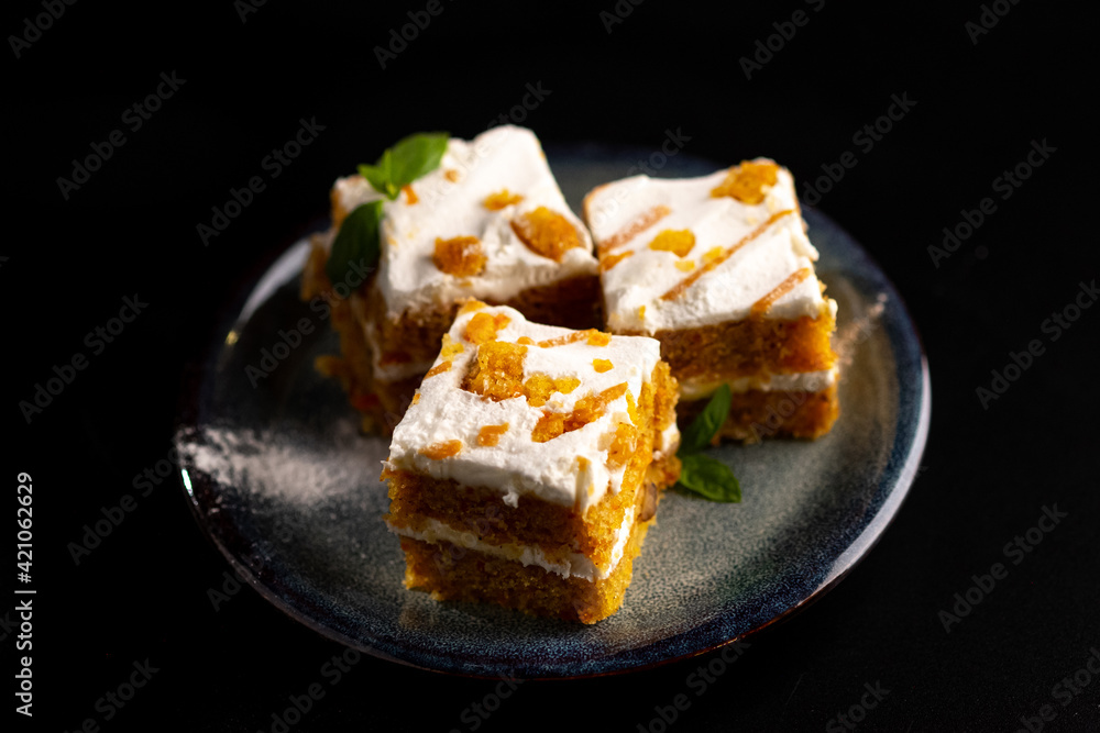 Carrot dessert cake on a plate on a black background. Carrot dessert cake on a plate on a black background.