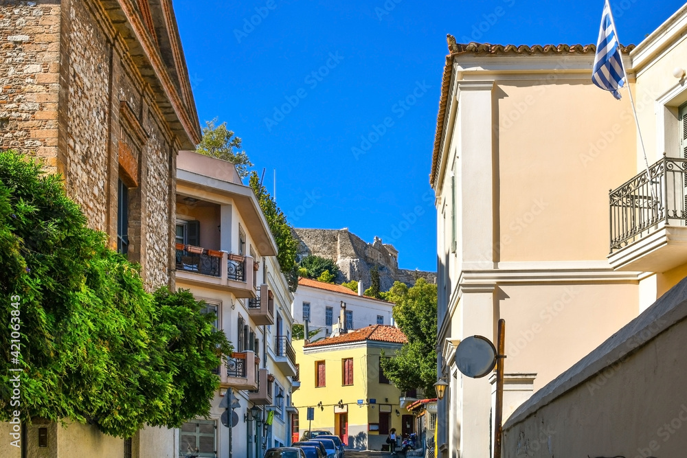View of a portion of the Acropolis Hill from the colorful residential streets of the Plaka District in Athens, Greece.