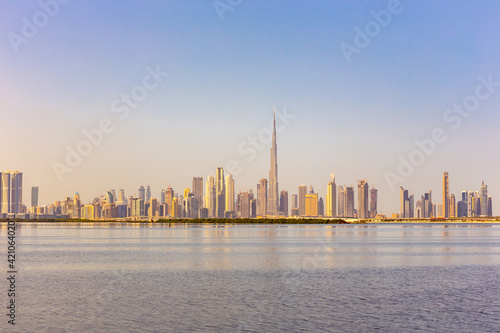 Dubai Downtown skyline landscape with reflections in Dubai Creek  warm golden colors  seen from Dubai Creek Harbour promenade.