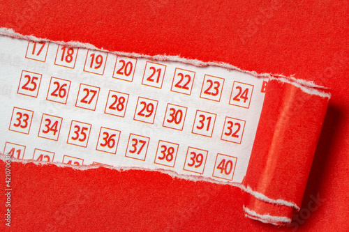 Red paper torn to reveal lottery ticket numbers