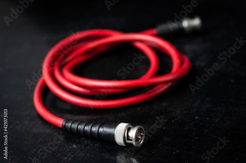 Red cable for transferring sdi signal through bnc connector on a dark background photo