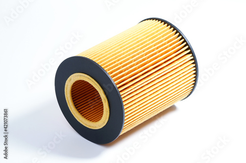 The oil filter lies on a white background. Replacement filter cartridge for cleaning oil of the car.