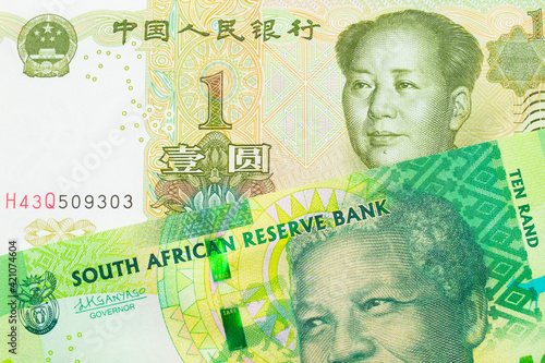 A macro image of a shiny, green 10 rand bill from South Africa paired up with a green and white one yuan note from China. Shot close up in macro.