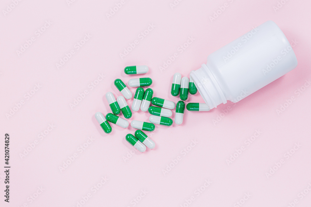 Yogurt capsules in a glass bottle on light pink background with copy space for your text. White probiotics capsules in pink background. Template medical blog social media. Yogurt capsules in a glass bottle on light pink background with copy space for your text. White probiotics capsules in pink background. Template medical blog social media.