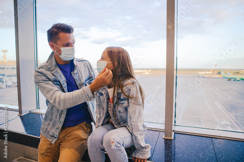 Dad and little girl with medical masks at airport. Protection against Coronavirus and gripp