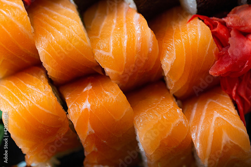 Tray with freshly prepared rolls with raw salmon, top view. Food from the delivery service close-up. Asian cuisine