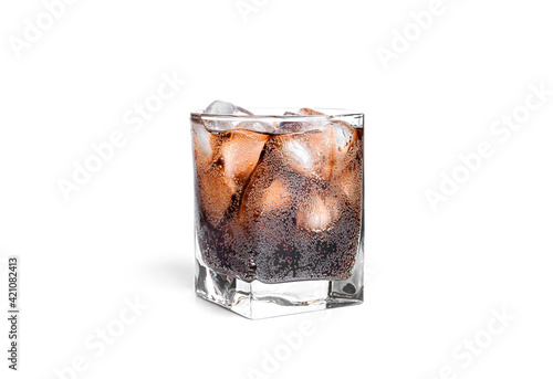 Cola with ice in a transparent glass isolated on a white background.