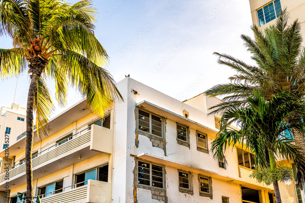 Obraz premium Rundown dilapidated broken art deco district building on Ocean drive street in South Beach of Miami, Florida with palm trees in summer