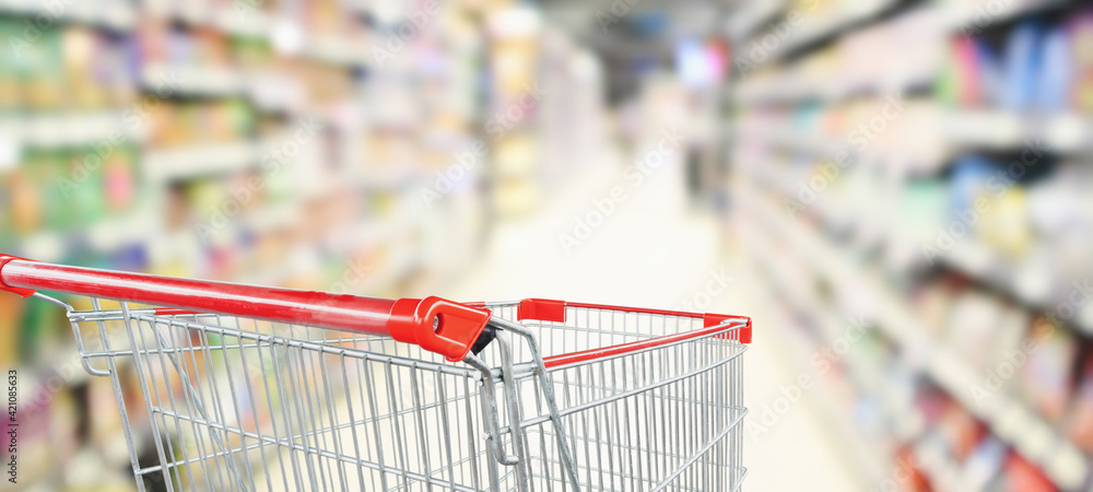 empty red shopping cart in supermarket aisle