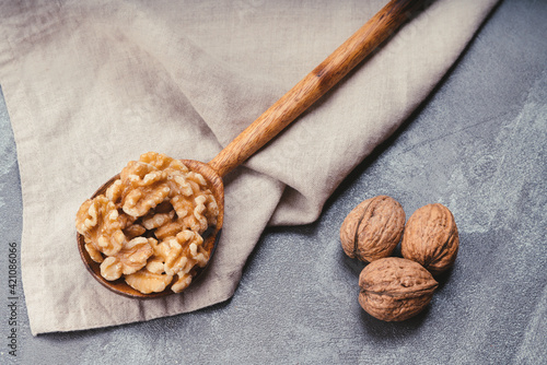 Photography wooden spoon with walnuts on linen tea towel