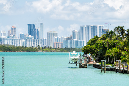 Bal Harbour, Miami Florida house dock with boat by light green turquoise ocean Biscayne Bay Intracoastal water and cityscape Sunny Isles Beach cityscape photo
