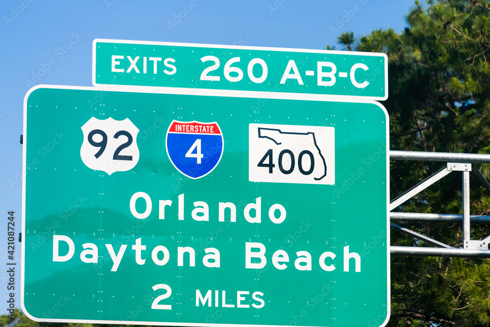 Road traffic sign for exits 260 A, B and C in Daytona Beach, Florida with direction to Orlando city on 92 or 400 local roads with interstate highway 4 in summer Road traffic sign for exits 260 A, B and C in Daytona Beach, Florida with direction to Orlando city on 92 or 400 local roads with interstate highway 4 in summer