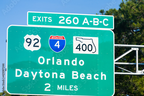 Road traffic sign for exits 260 A, B and C in Daytona Beach, Florida with direction to Orlando city on 92 or 400 local roads with interstate highway 4 in summer