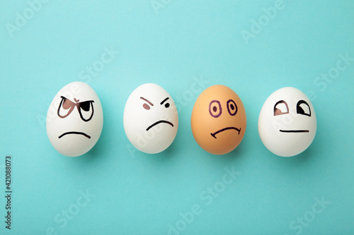 Eggs with different emotions on his face. Easter composition with copy space on blue background. Stop racism