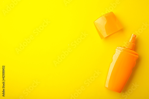 Sun protection bottle on yellow background. Summer vacation