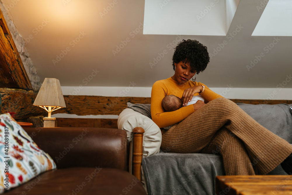 Obraz premium Young mother breastfeeding the baby