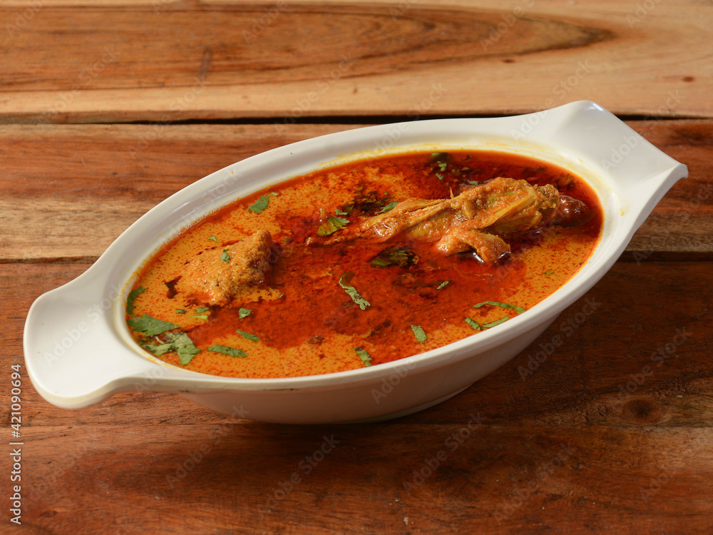 Chicken masala made of indian spices served in a bowl over a wooden rustic background. selective focus Chicken masala made of indian spices served in a bowl over a wooden rustic background. selective focus