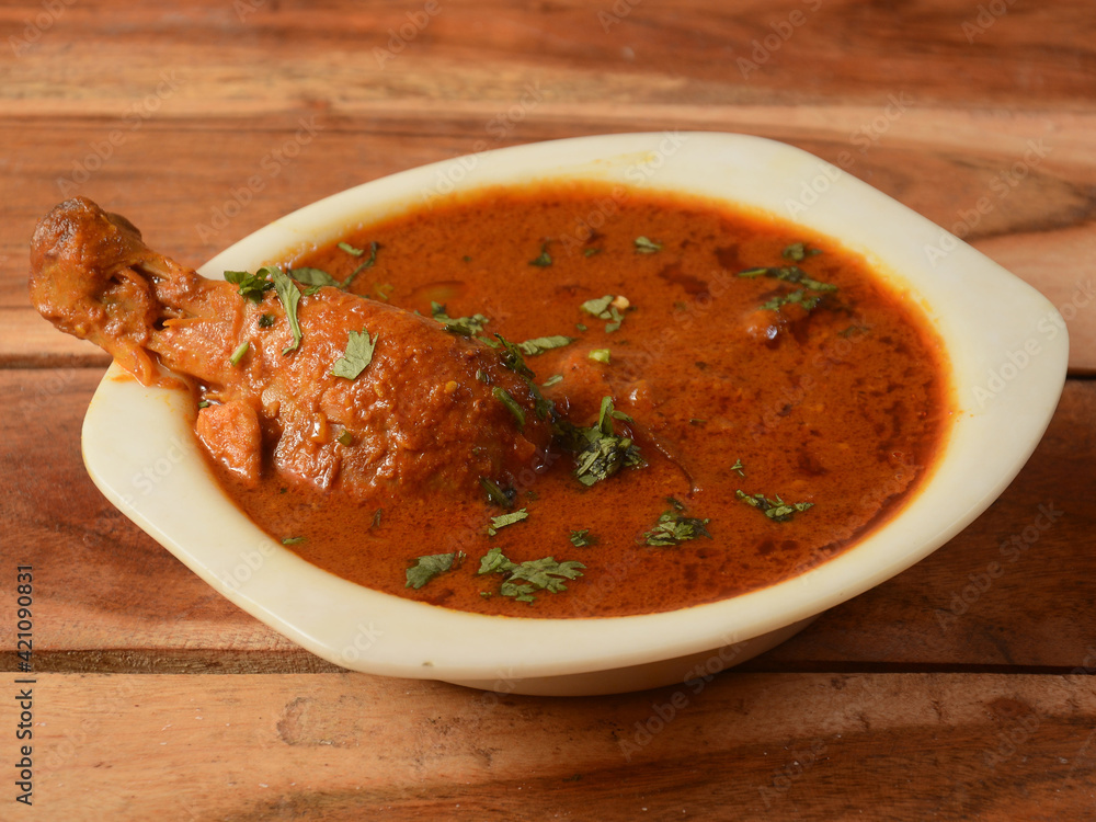 Chicken masala made of indian spices served in a bowl over a wooden rustic background. selective focus Chicken masala made of indian spices served in a bowl over a wooden rustic background. selective focus