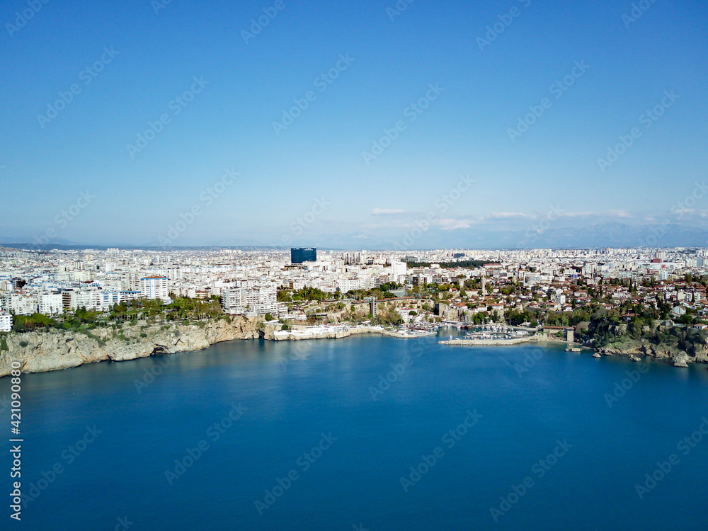 Aerial photograph of Antalya bay in Antalya city from high point of drone fly on sunny day in in Turkey. Amazing aerial cityscape view from birds fly altitude on beautiful town and sea full of yahts