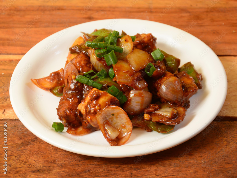 Chilli Chicken is an Indian Chinese starter served over a wooden rustic background. selective focus Chilli Chicken is an Indian Chinese starter served over a wooden rustic background. selective focus