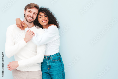 Smiling beautiful woman and her handsome boyfriend. Happy cheerful multiracial family having tender moments on grey background  in studio. Multiethnic models hugging. Embracing each other.Love concept © halayalex