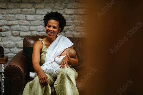 Smiling woman breastfeeding her baby photo
