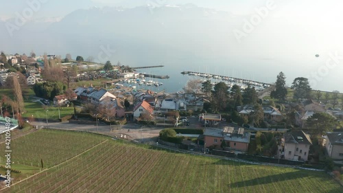 Drone flying over small Swiss town towards yacht harbor on lake Geneva