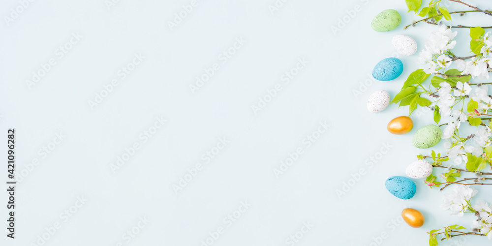 Flat lay easter composition with spring flowers and easter eggs on a light background