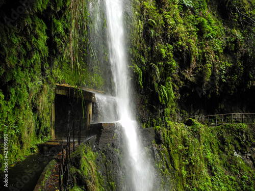 Waterfall crashing on a small shelter on the Levada da Ribeira da Janela  Madeira  Portugal