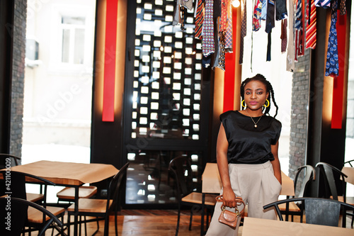 Young african woman in black blouse at cafe.