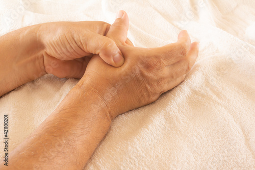 Adult man with pain in the hands. Joint pain in young adults. Hands calming the pain.