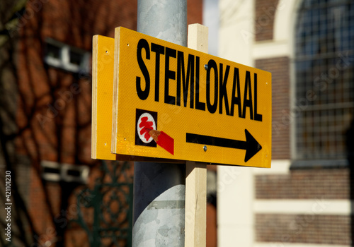 Dutch-language sign that points the way to the polling station and warns you that you must bring ID with you.