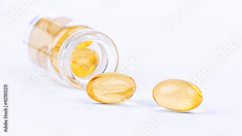 Medical yellow pill capsules and a glass bottle. Pharmaceutical medicament for health.
