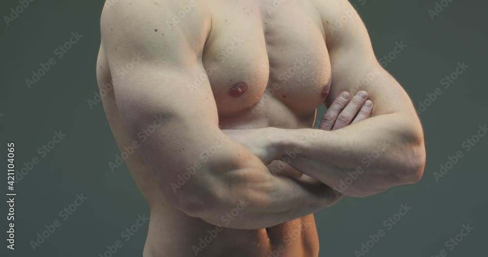 Close up video of strong muscular man crossing hands on torso. Trained sportive guy with fit abs. Ad of sports nutrition Close up video of strong muscular man crossing hands on torso. Trained sportive guy with fit abs. Ad of sports nutrition