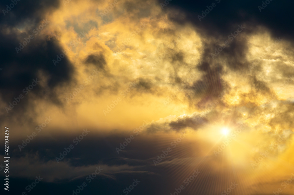 Dramatic dark cumulus cloud sunset sky with rays. Climate background