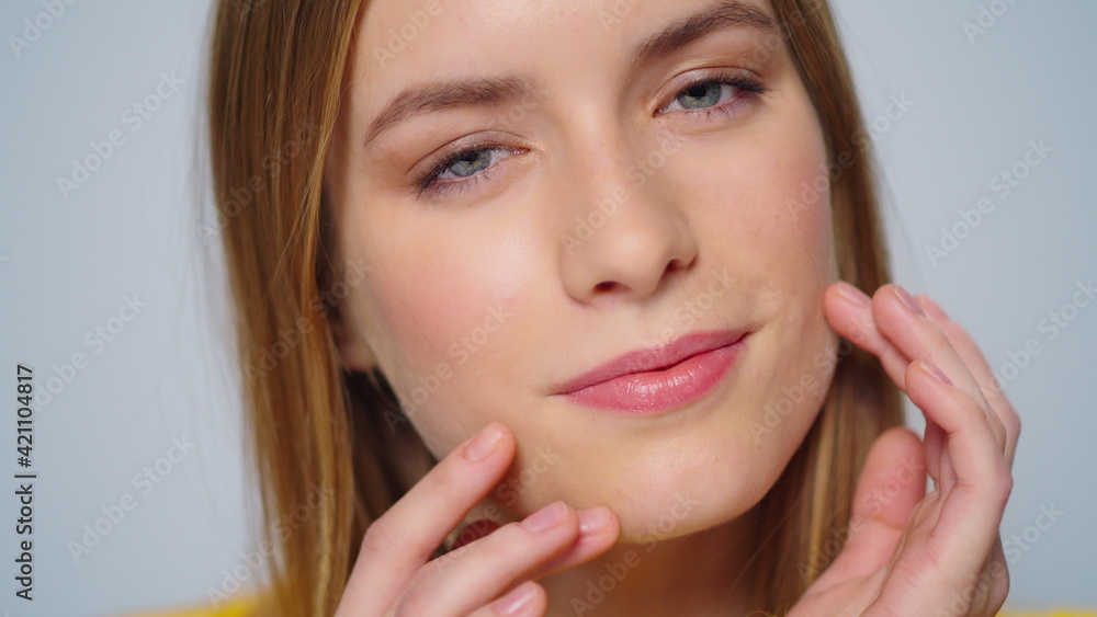 Closeup attractive smiling woman touching face with hands at camera indoors. Closeup attractive smiling woman touching face with hands at camera indoors.
