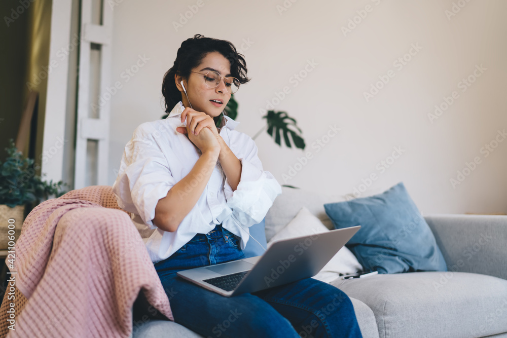 Pretty woman watching video on laptop on soft couch Pretty woman watching video on laptop on soft couch