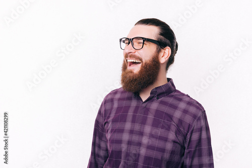 Portrait of handsome man with beard wearing eyeglasses and laughing © Vulp