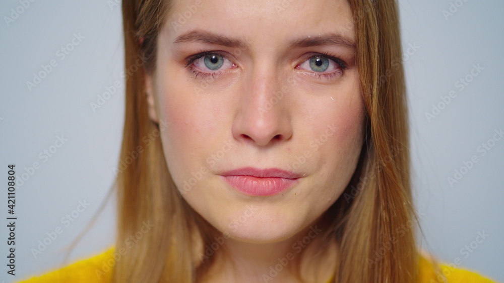 Naklejka premium Portrait of upset woman looking at camera in studio.Unhappy girl crying.