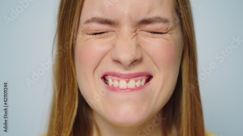 Closeup cheerful woman making funny faces on grey background in studio.