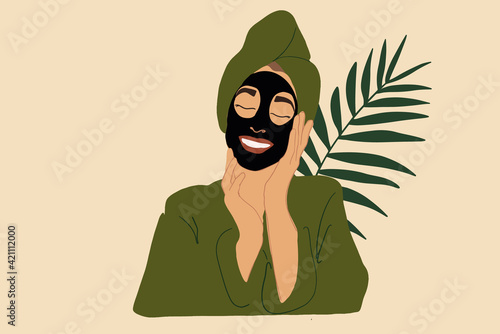 Pretty smiling woman with black activated carbon mask on the face in green bathrobe and towel with green leaf on background. Clean and detox skincare. Vector Illustration.
