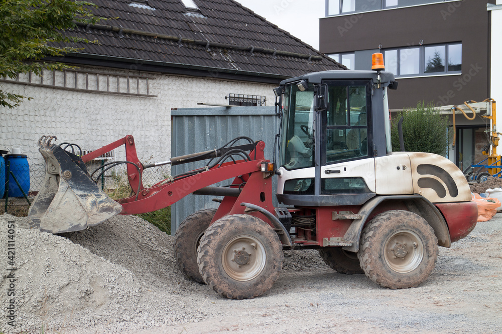 Kleiner Bulldozer baggert Kies auf einer Baustelle Kleiner Bulldozer baggert Kies auf einer Baustelle